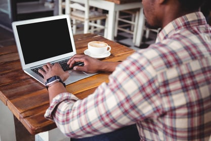 Man using laptop in cafeteria